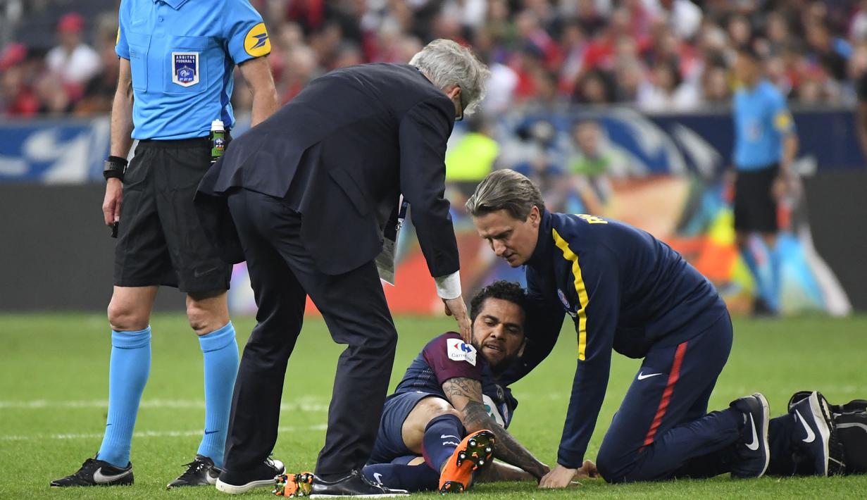 Petugas medis PSG memeriksa Daniel Alves saat laga Piala Prancis melawan Les Herbiers di Stade de France, Saint-Denis, (8/5/2018). Dani harus menjalani pemeriksaan ketat dari tim dokter Brasil. (AFP/Damien Meyer)