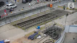 Petugas berjaga dekat lokasi ditemukannya rel trem di proyek pembangunan MRT Jakarta fase 2A paket kontrak atau CP 203 Glodok-Kota, Selasa (28/12/2021). Rel trem dari era kolonial Belanda tersebut ditemukan saat penggalian proyek MRT Fase 2A Glodok-Kota. (Liputan6.com/Faizal Fanani)