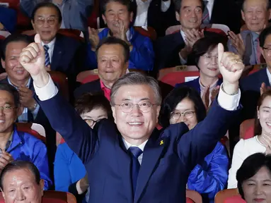 Kandidat Presiden Korsel, Moon Jae-in mengangkat tangan usai hasil hitung cepat memperlihatkan dia unggul dibanding calon lainnya di Seoul, Selasa (9/5). Calon Partai Demokrat itu menang telak dengan mengantongi 41,4 persen suara (AP Photo/Ahn Young-joon)