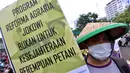 Massa tani memapangkan spanduk tuntutan dalam unjuk rasa di depan Istana Negara, Jakarta, Rabu (27/9). Dalam aksinya yang memperingati Hari Tani Nasional, mereka meminta Presiden segera memperbaiki ketimpangan struktur agraria. (Liputan6.com/Johan Tallo)