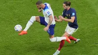 Bek Inggris Kyle Walker berebut bola dengan gelandang Prancis Adrien Rabiot pada perempat final Piala Dunia 2022 di Al Bayt Stadium, Al Khor, Minggu (11/12/2022) dini hari WIB. Gol penalti Harry Kane (54’) tidak cukup untuk mengimbangi gol dari Aurelien Tchouameni (17’) dan Olivier Giroud (78’). (AP Photo/Hassan Ammar)