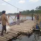 Warga sedang berjalan menuju rakit bambu untuk menyebrangi perairan Saguling di wilayah Kampung Sekecengek, Desa Cangkorah, Kecamatan Batujajar, Kabupaten Bandung Barat (KBB)/Liputan6.com