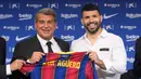 Penyerang Sergio Aguero (kanan) berpose dengan presiden Joan Laporta selama presentasi resminya sebagai pemain baru Barcelona di stadion Camp Nou, Spanyol (31/65/2021).  Barcelona dan Sergio Aguero sama-sama sepakat untuk menyelipkan klausul pelepasan dalam kontraknya. (AFP Photo/Lluis Gene)