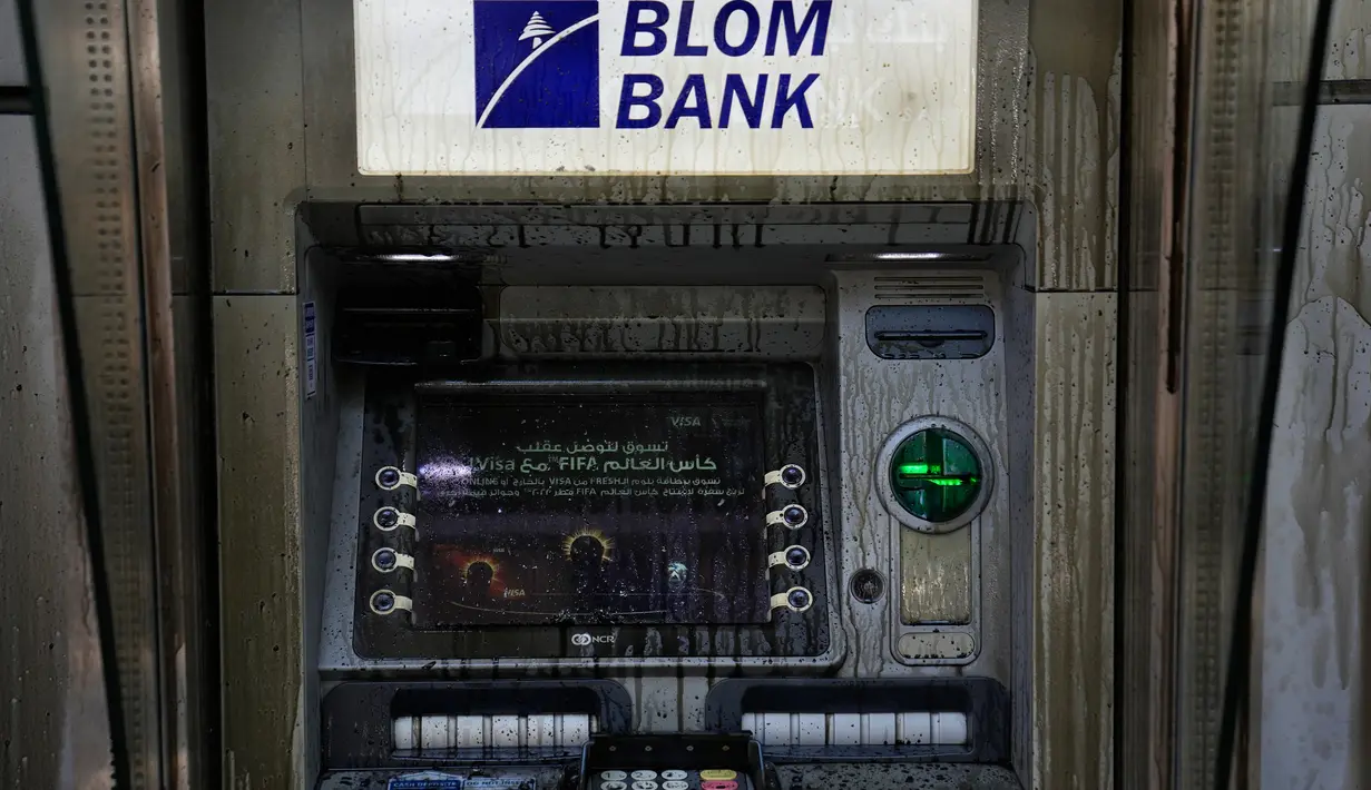 Sebuah ATM dikotori dengan bahan bakar diesel setelah dirusak oleh deposan yang marah yang menyerang sebuah bank, Beirut, Lebanon, Rabu (14/9/2022). Adanya pembatasan dan penahanan tabungan di bank membuat masyarakat putus asa untuk mengakses tabungan mereka dan marah pada sektor perbankan yang dianggap sebagai kartel korup. (AP Photo/Hussein Malla)