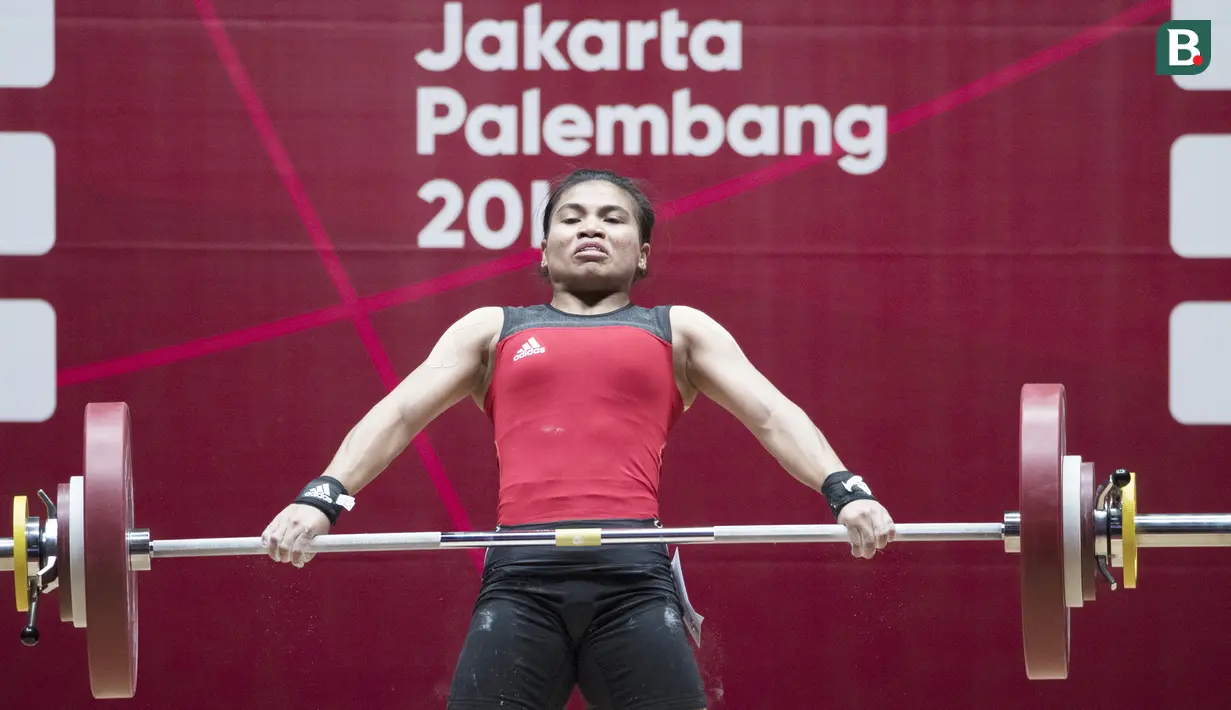 Atlet angkat besi, Sri Wahyuni, saat berlaga pada Asian Games di JIExpo, Jakarta, Senin, (20/8/2018). Sri Wahyuni menyumbang medali perak dengan total angkatan 195 kg. (Bola.com/Vitalis Yogi Trisna)