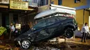 Sebuah mobil di depan toko rental kendaraan rusak akibat diterjang banjir bandang yang melanda pulau Symi di Yunani, Rabu (15/11). Banjir bandang itu melanda tiga kota terpisah di Negeri Dewa tersebut. (Argiris Madikos /Eurokinissi via AP)