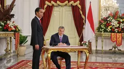 Perdana Menteri Hongaria, Y.M. Tuan Viktor Orban (kanan) mengisi buku tamu didampingi Presiden Joko Widodo di Istana Merdeka, Jakarta, Senin (1/2). (Liputan6.com/Faizal Fanani)