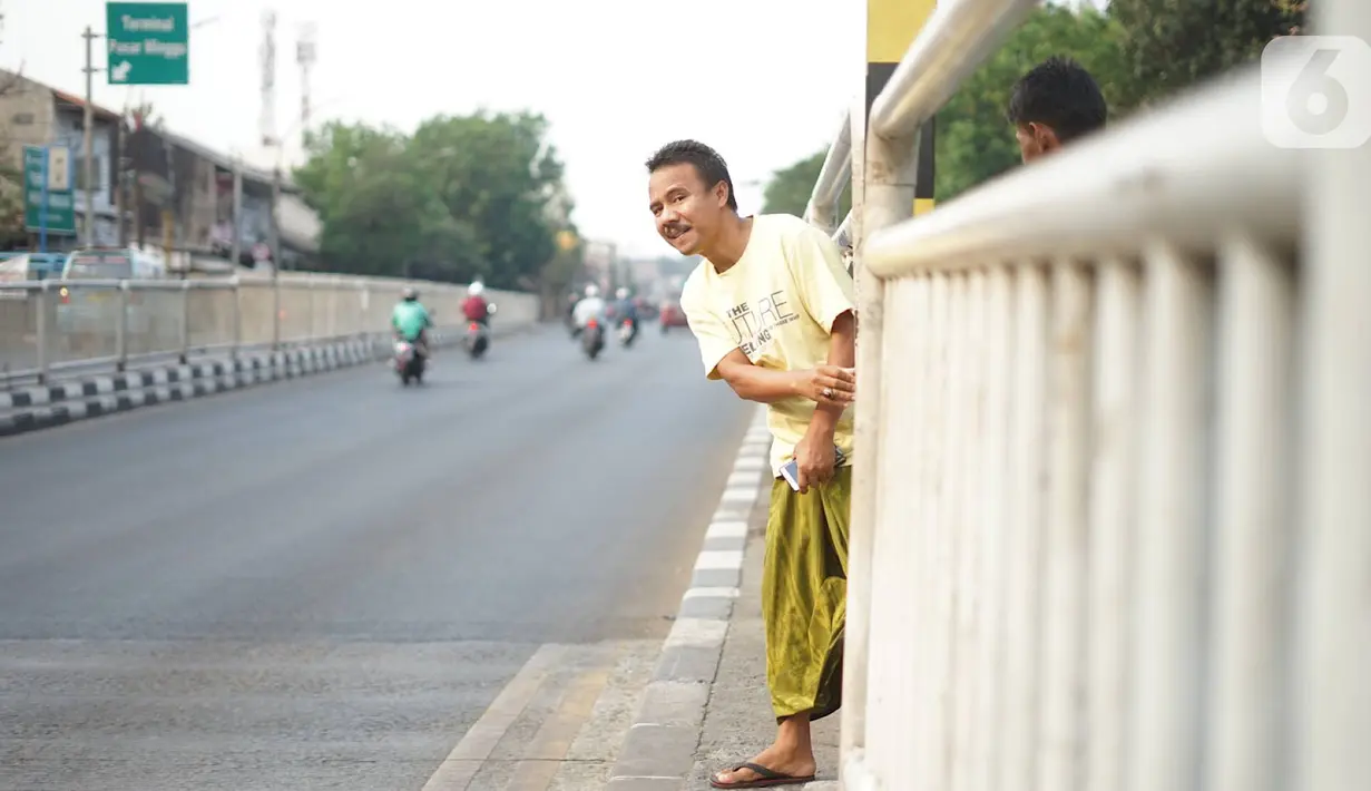 Warga menerobos celah pagar pembatas jalan di depan Stasiun Pasar Minggu, Jakarta, Rabu (16/10/2019). Jauhnya jembatan penyeberangan orang (JPO) membuat warga memanfaatkan celah pagar pembatas tersebut sebagai akses menyeberang, meski berbahaya bagi keselamatan. (Liputan6.com/Immanuel Antonius)