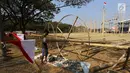 Pekerja memasang bendera Merah Putih pada pohon pinang untuk acara panjat pinang kolosal di kawasan Ancol, Jakarta, Kamis (15/8/2019). Ancol Taman Impian menggelar berbagai acara dalam menyambut HUT ke-74 RI, salah satunya adalah Panjat Pinang Kolosal. (Liputan6.com/Herman Zakharia)