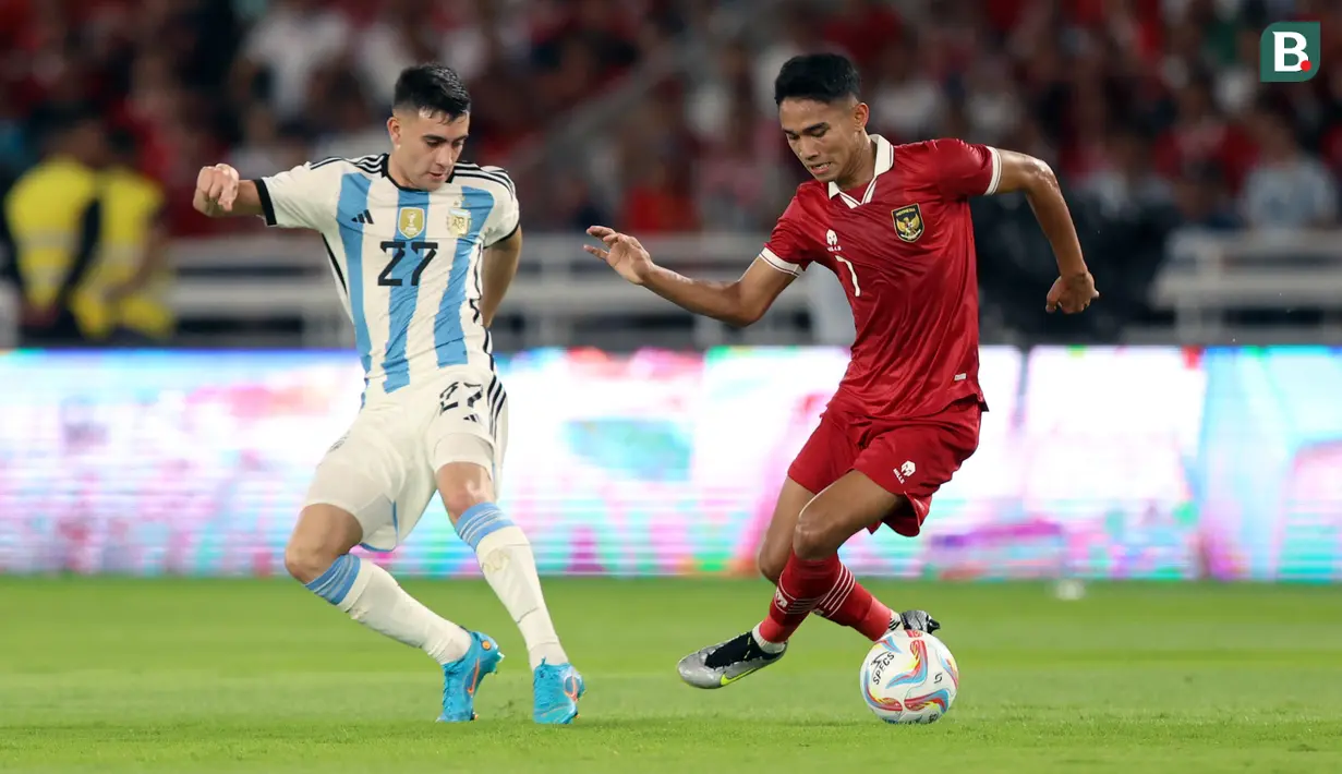 Pemain Timnas Indonesia, Marselino Ferdinan (kanan) berusaha melewati pemain Argentina, Facundo Buonanotte pada laga FIFA Matchday di Stadion Utama Gelora Bung Karno (SUGBK), Senayan, Jakarta, Senin (19/06/2023). (Bola.com/Bagaskara Lazuardi)