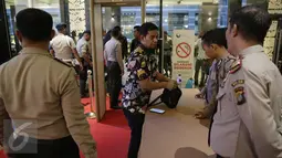 Petugas kepolisian memeriksa pengunjung yang hendak masuk dalam Debat terakhir Pilgub DKI Jakarta 2017, Jakarta, Rabu (12/4). Subtema dari debat tersebut terkait dengan masalah transportasi, tempat tinggal, reklamasi. (Liputan6.com/Faizal Fanani)