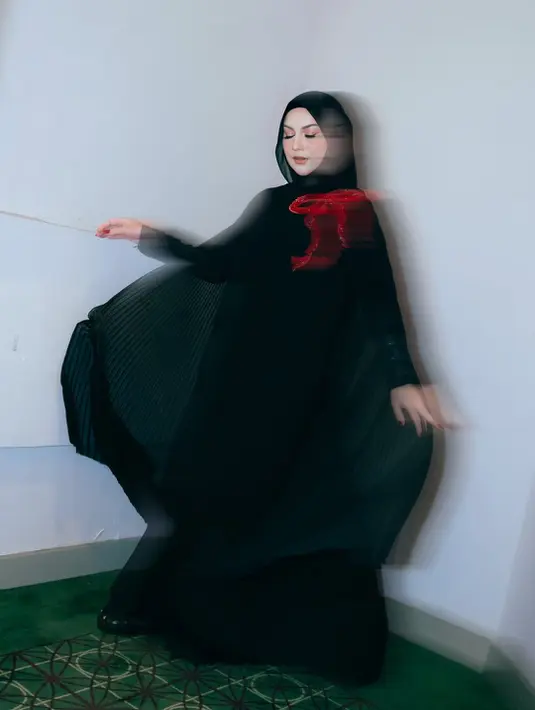 Aksen pleated cape dan pita sequin berwarna merah jadi sentuhan glamor pada busana Irish Bella [@_irishbella_]