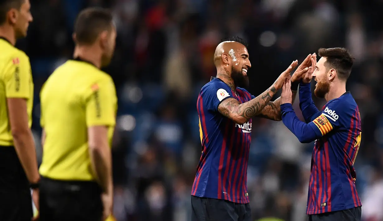 Pemain Barcelona, Lionel Messi dan rekannya, Chile Arturo Vidal berselebrasi setelah menang atas Real Madrid pada laga leg kedua semifinal Copa del Rey di Stadion Santiago Bernabeu, Rabu (27/2). Barcelona menang telak 3-0.  (OSCAR DEL POZO / AFP)