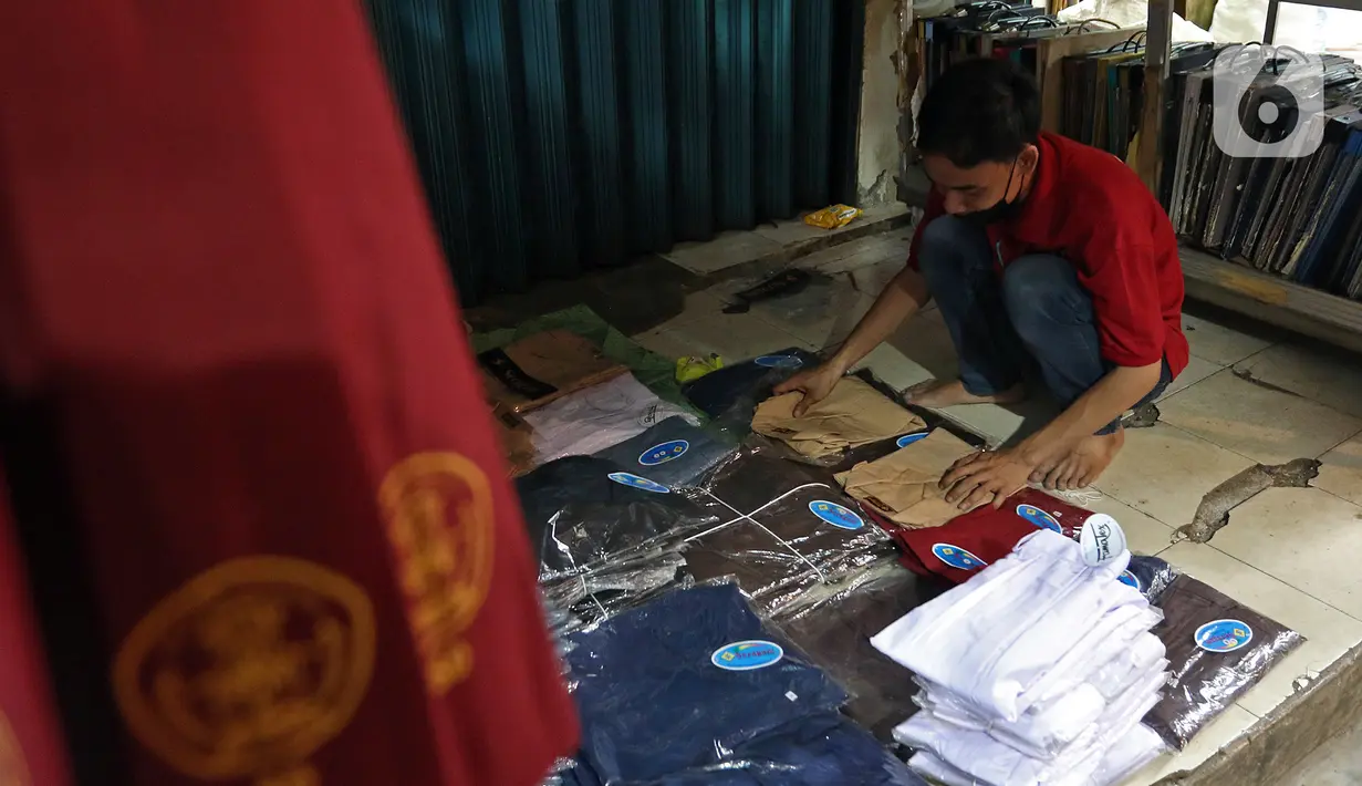 Pedaan 
Pedagang menata seragam sekolah di Pasar Mester, Jakarta , Minggu (29/8/2021). Menurut pedagang, penjualan seragam sekolah kembali meningkat hingga 30 persen jelang masuk sekolah tatap muka yang dilaksanakan kembali pada 30 Agustus 2021. (Liputan6.com/Herman Zakharia)