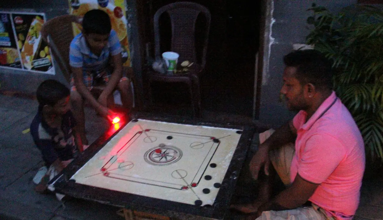 Sebuah keluarga bermain karambol di tengah pemadaman listrik di Kolombo, Sri Lanka 17/8/2020). Akibat pemadaman listrik tersebut kegiatan bisnis dan kehidupan sehari-hari terpaksa terhenti. (Xinhua/A. Hapuarachchi)