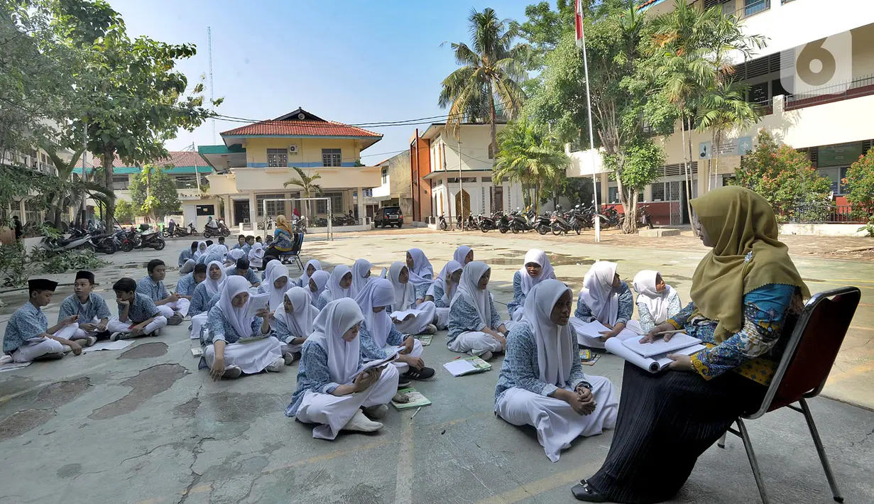Siswa kelas VIII belajar mata pelajaran Sejarah Kebudayaan di halaman sekolah Mts. Hidayatul Umam di Cinere, Depok, Kamis (7/11/2019). Kementerian PPPA melaksanakan kegiatan hari belajar di luar kelas yang serentak di seluruh Indonesia pada Kamis (7/11). (merdeka.com/Arie Basuki)