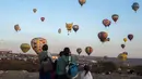 Warga melihat balon udara yang menghiasi langit di Cajititlan, Meksiko, Minggu (7/5).  Festival balon udara ini menjadi tontonan menarik bagi warga sekitar dan wisatawan. (AFP PHOTO / Hector Guerrero)