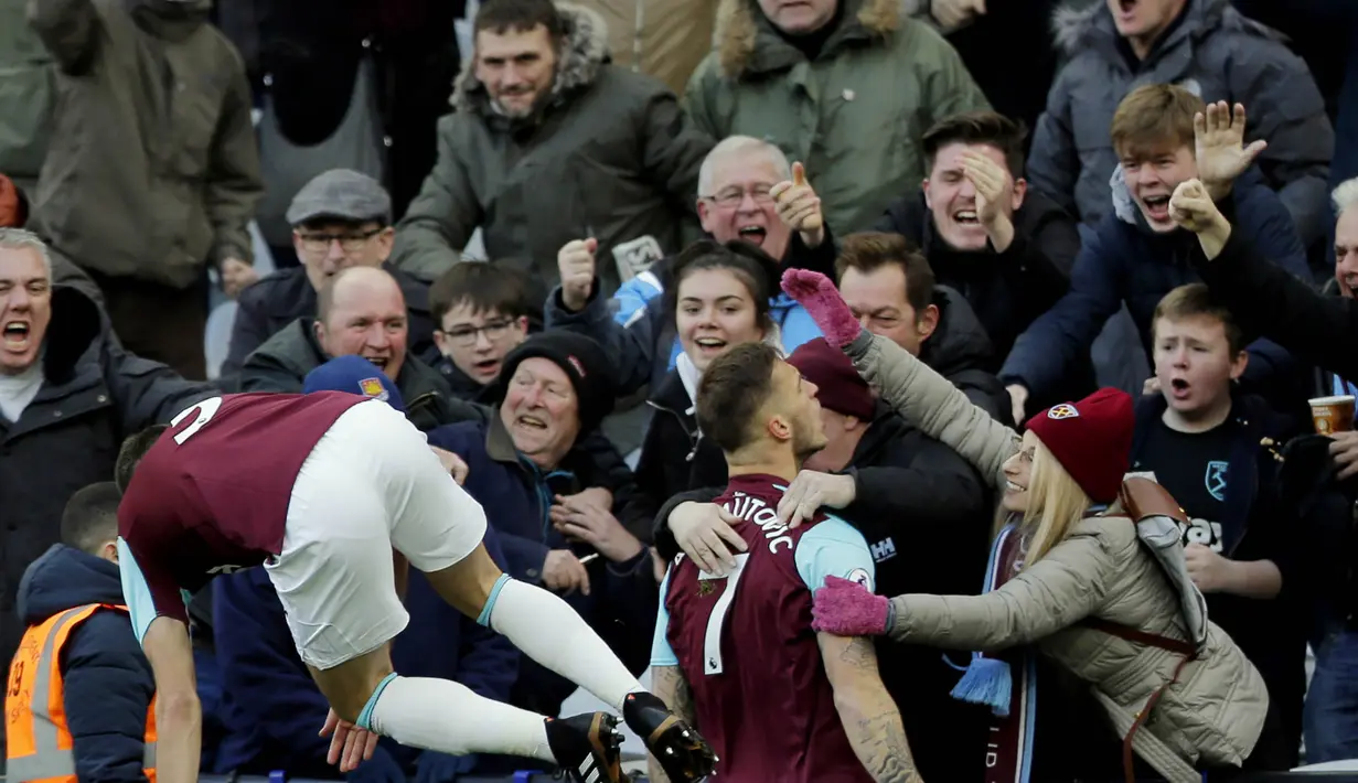 Suporter West Ham United memeluk Marko Arnautovic usai mencetak gol ke gawang Chelsea pada laga Premier League di Stadion London, Sabtu (10/12/2017). Chelsea Takluk 0-1 dari West Ham United. (AP/Alastair Grant)