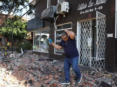 Seorang pria keluar dari gedung apartemen setelah gempa bumi melanda Cali, Kolombia, Senin, 10 Agustus 2026. (Foto AP/Santiago Saldarriaga)