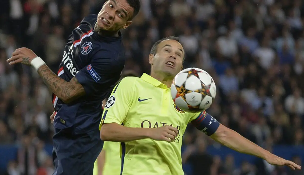 Pemain belakang PSG, Gregory Van der Wiel (kiri), berebut bola atas dengan gelandang Barcelona, Andres Iniesta, saat berlaga di pertemuan kedua Liga Champions 2014-2015 Grup F di Stadion Parc des Princes, Paris (1/10/2014). (AFP PHOTO/Miguel Medina)