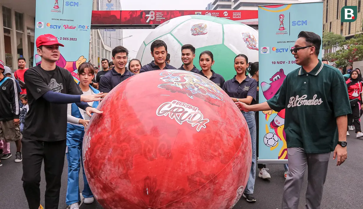 Sejumlah artis SCM dan juga Abang None Jakarta membawa sebuah bola raksasa dalam rangkaian acara Trophy Experience saat Hari Bebas Kendaraan Bermotor , Minggu (15/10/2023). Emtek Grup secara resmi menjadi pemegang hak siar dan menyajikan tayangan yang ciamik untuk seluruh pertandingannya. (Bola.com/Bagaskara Lazuardi)