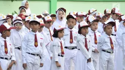 Seorang murid menguap diantara rekannya di sela upacara bendera di SDN Jatinegara Kaum 15 Pagi, Jakarta, Senin (15/7/2019). Sebanyak 32 anak menjadi murid baru SDN tersebut pada hari pertama masuk sekolah tahun ajaran 2019/2020. (merdeka.com/Iqbal S Nugroho)