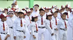 Seorang murid menguap diantara rekannya di sela upacara bendera di SDN Jatinegara Kaum 15 Pagi, Jakarta, Senin (15/7/2019). Sebanyak 32 anak menjadi murid baru SDN tersebut pada hari pertama masuk sekolah tahun ajaran 2019/2020. (merdeka.com/Iqbal S Nugroho)