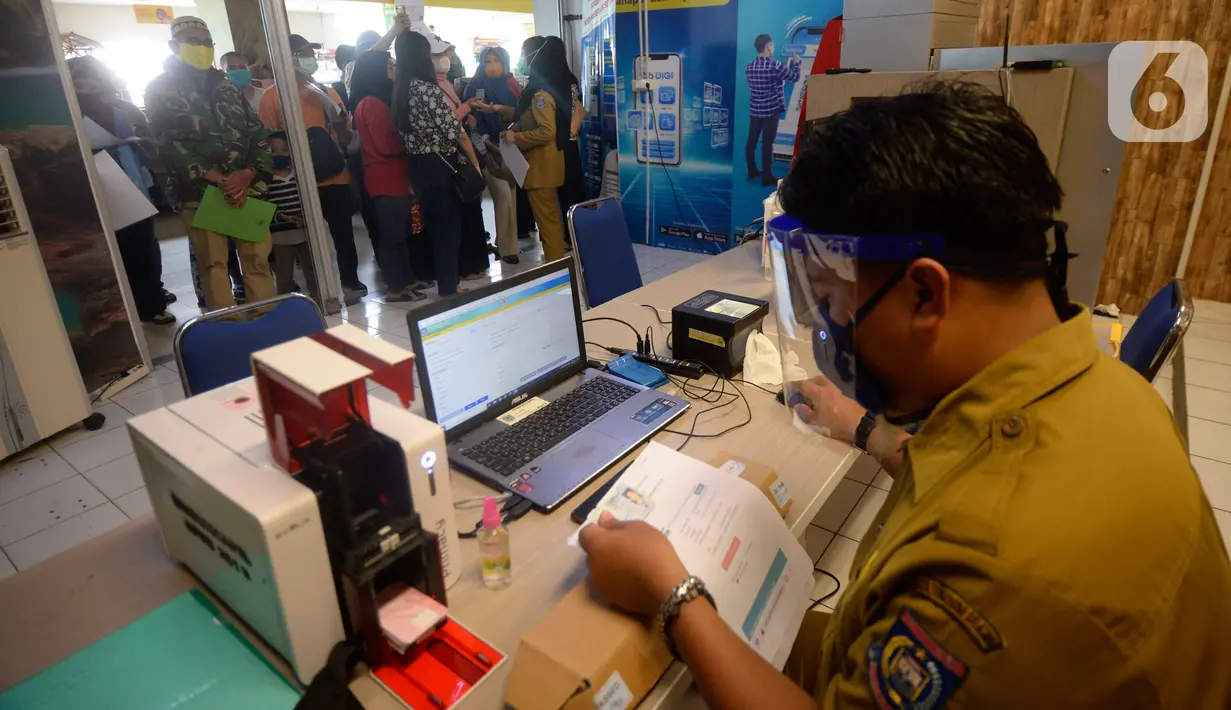 Petugas melayani warga yang akan melakukan pencetakan di mesin Anjungan Dukcapil Mandiri (ADM) di Pamulang Square, Tangerang Selatan, Senin (15/9/2020). Pemkot Tangsel memudahkan pelayanan kependudukan untuk membuat KTP El, Kartu Identitas Anak dan Kartu Keluarga. (merdeka.com/Dwi Narwoko)
