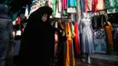 Seorang wanita muslim Kashmir mencari pakaian sebelum Idul Fitri di Srinagar, Kashmir yang dikuasai India (2/6/2019). Idul Fitri, menandai berakhirnya bulan puasa Ramadan. (AP Photo/Mukhtar Khan)