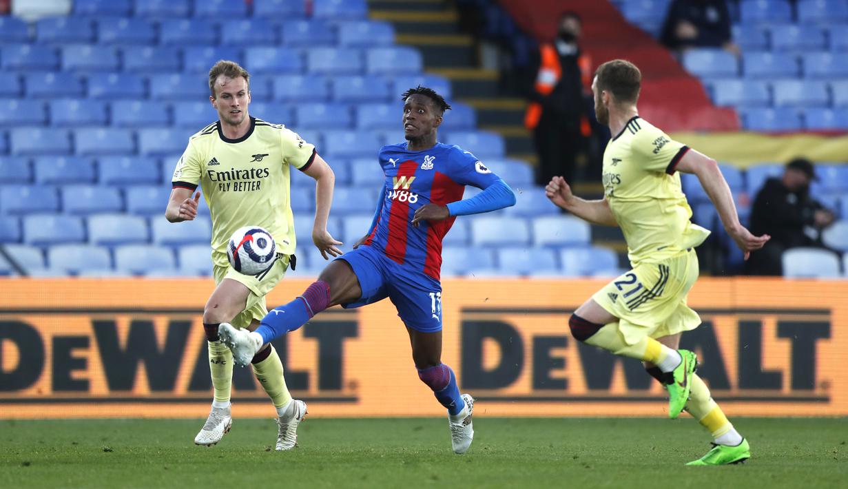Penyerang Crystal Palace, mengontrol bola melewati bek Arsenal, Calum Chambers pada pekan ke-37 Liga Inggris, Kamis (20/5/2021) dini hari WIB. The Gunners -julukan Arsenal- menang dengan skor 3-1 di markas Crystal Palace. (Frank Augstein, Pool)