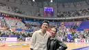 Pasangan Harris Vriza dan Haviza Devi Anjani juga tampak menonton pertandingan FIBA terakhir di Jakarta. Harris tampil kasual dengan kemeja putih lengan pendek dan celana kargo putih gading. [Foto: Instagram/harrisvriza]