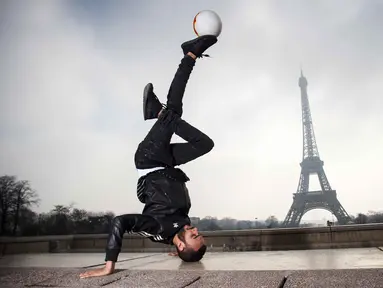 Moss dari S3 Society dance group beraksi bersama bola di the Place du Trocadero, dengan  latar menara Effeil, Paris, Jumat (18/3/2016).  S3 Society akan tampil pada Euro 2016 Pracis tanggal 10 Juni-10 Juli 2016. (AFP/Lionel Bonaventure)
