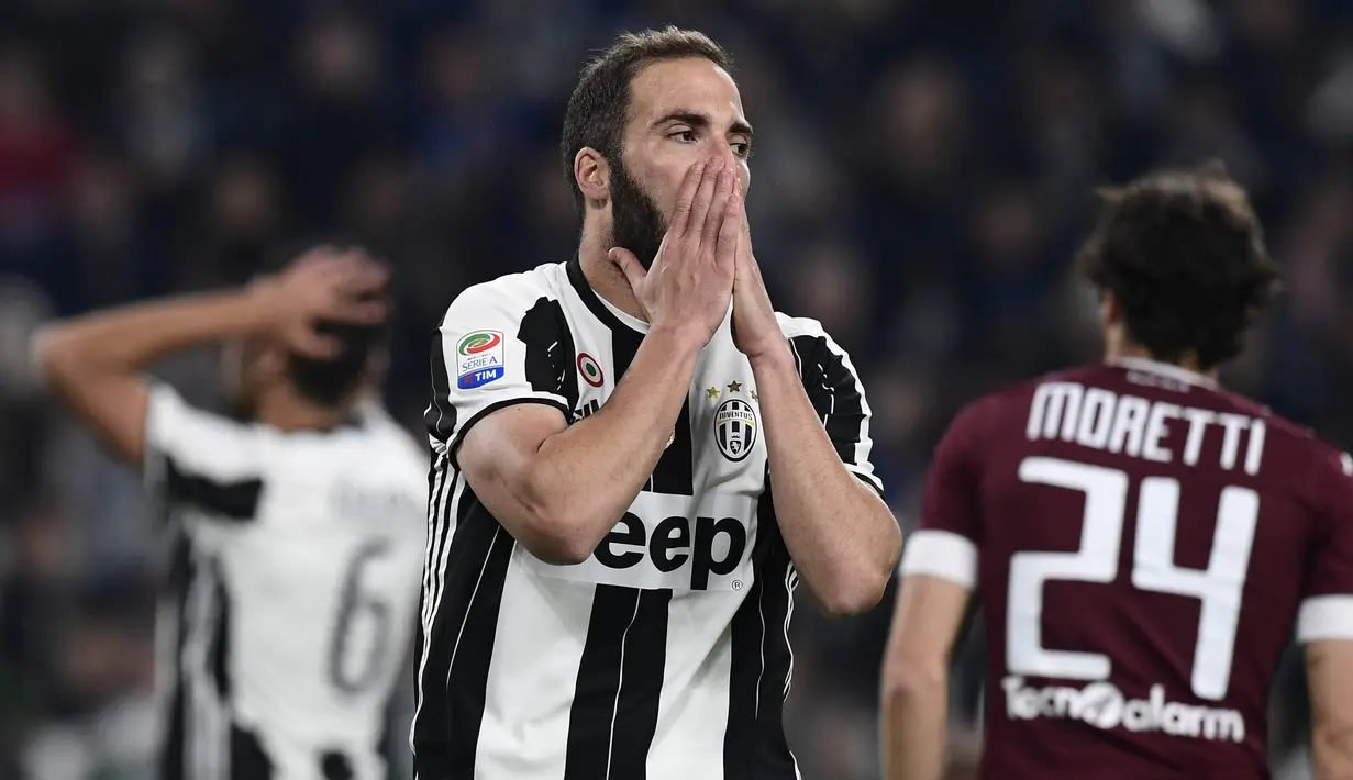 Striker Juventus, Gonzalo Higuain, tampak kecewa usai tim nya ditahan imbang Torino pada laga lanjutan liga Italia di Juventus Stadium, Sabtu (6/5/2017). Skor berakhir imbang 1-1. (AFP/Miguel Medina)