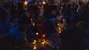 Orang-orang menyalakan lilin membentuk peta Ukraina, untuk mengenang nyawa yang hilang, di depan monumen Taras Shevchenko, di Lviv, Ukraina barat, Selasa malam (5/4/2022). Orang-orang Ukraina berkumpul untuk momen menghormati nyawa yang hilang dalam perang. (AP Photo/Nariman El- Mofty)