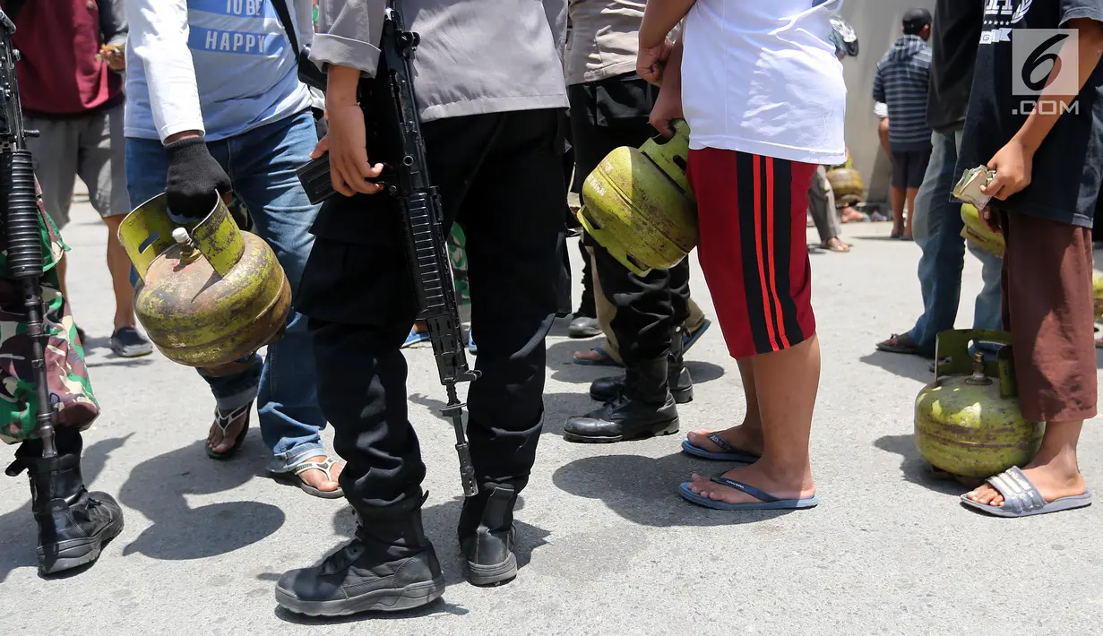 Warga membawa tabung gas elpiji 3 kg saat operasi pasar elpiji di SPBU Ki Hajar Dewantara di Palu, Sulawesi Tengah, Senin (8/10). Pertamina melakukan operasi pasar elpiji 3 kg dan 12 kg di 16 titik pascagempa dan tsunami Palu. (Liputan6.com/Fery Pradolo)