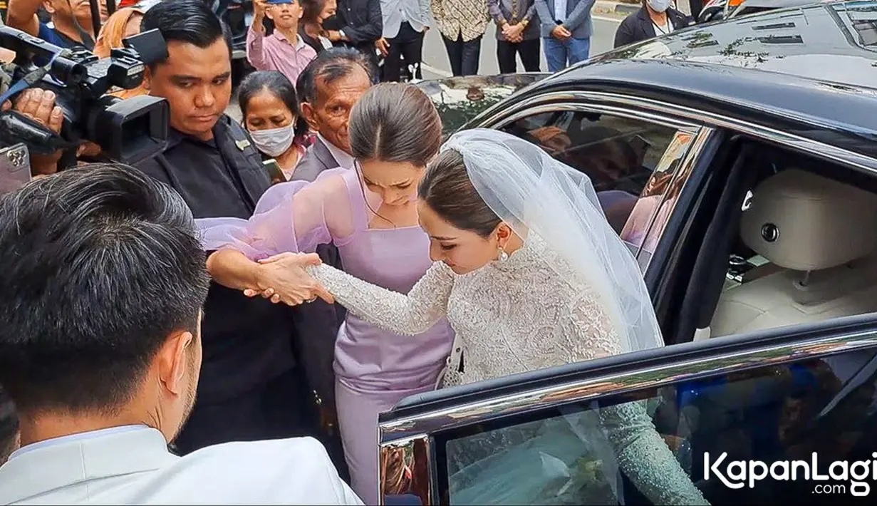 Tiba di lokasi, Yakup dengan sigap membukakan pintu mobil untuk calon istrinya. Dibantu seorang perempuan, bintang sinetron Ganteng Ganteng Serigala turun dari mobil. [Foto: Muhammad Akrom Sukarya/© KapanLagi.com]