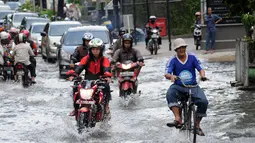 Sejumlah pengendara mencoba melintasi genangan air di jalan Kemang Raya, Jakarta pada Selasa (10/2/2015). (Liputan6.com/Helmi Fithriansyah)