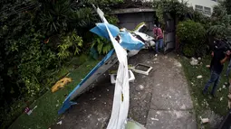 Bagian badan pesawat yang jatuh di halaman rumah seseorang di Guatemala City, Guatemala, Sabtu (21/11/2015). Akibat kejadian ini dua awak pesawat dibawa kerumah sakit. (REUTERS/Jorge Dan Lopez)