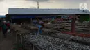 Pekerja menjemur ikan asin di Sentra Pengolahan Ikan Asin Kampung Nelayan Muara Angke, Jakarta, Selasa (16/11/2021). Produksi ikan asin mengalami harga stabil saat pandemi Covid-19 di level 1 dengan harga jual kisaran Rp 38 ribu per kilogram meski cuaca kurang baik. (merdeka.com/Imam Buhori)