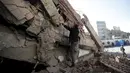Seorang karyawan memanjat salah satu bangunan yang runtuh di Sanaa, Yaman, (5/1). Bangunan ini hancur setelah  mendapat serangan udara dari Arab Saudi. (REUTERS / Khaled Abdullah)