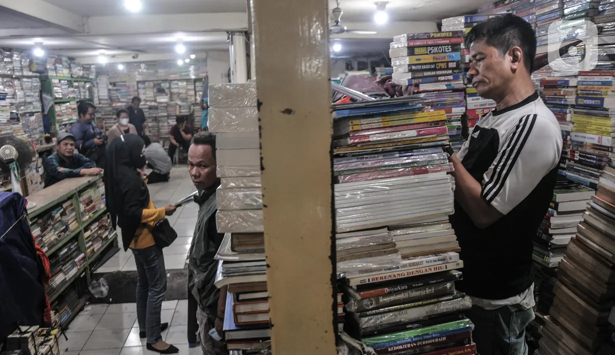 Warga saat memilih buku pelajaran sekolah di Pasar Buku Kwitang, Jalan Kramat Raya, Kecamatan Senen, Jakarta Pusat, Minggu (17/7/2022). Kembali diberlakukannya pembelajaran tatap muka (PTM) membuat penjualan buku sekolah di Pasar Buku Kwitang mengalami peningkatan hingga 60 persen . (merdeka.com/Iqbal S Nugroho)