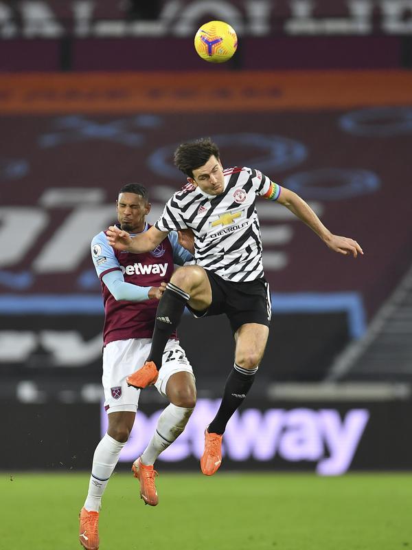 Bek Manchester United, Harry Maguire berebut bola udara dengan pemain West Ham, Sebastien Haller pada pertandingan lanjutan Liga Inggris di stadion London di London, Inggris, Minggu (6/12/2020). MU menang 3-1 atas West Ham. (Justin Setterfield/Pool Via AP)