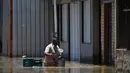 Seorang pria dengan sepedanya mengarungi air di jalanan yang tergenang banjir di komunitas Pilar di Duque de Caxias, Negara Bagian Rio de Janeiro, Brasil, pada 15 Januari 2024. (Mauro PIMENTEL/AFP)