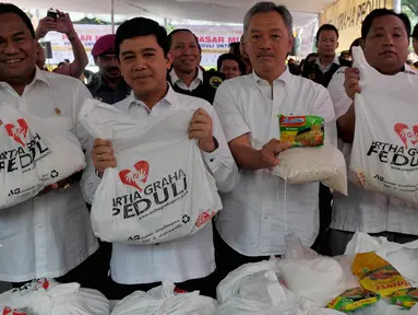 Mendag Rachmat Gobel (kiri) bersama Menpan RB, Yuddy Chrisnandi (kedua kiri) dan pemilik Artha Graha Group Tomy Winata (kedua kanan) menunjukan paket sembako saat program pasar murah di Jakarta, Senin (29/6/2015). (Liputan6.com/Johan Tallo)