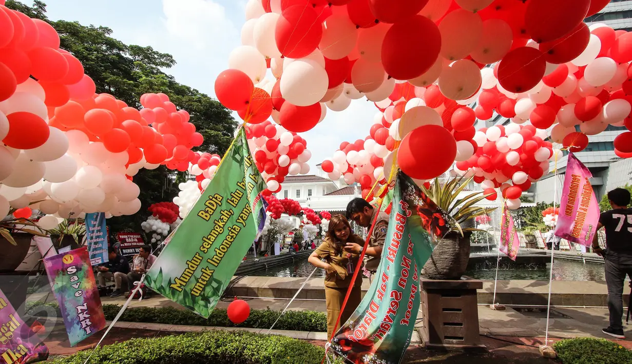 Pegawai berswafoto dengan balon merah putih yang menghiasi halaman Balai Kota DKI Jakarta, Senin (8/5). Sama halnya seperti karangan bunga, balon tersebut juga dikirim pendukung Basuki Tjahaja Purnama dan Djarot Saiful Hidayat (Liputan6.com/Faizal Fanani)