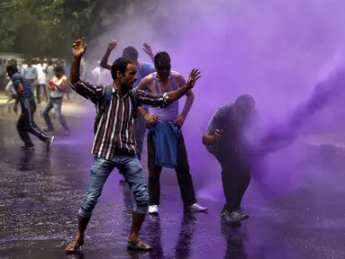 Sejumlah PNS terkena semprotan meriam air yang ditembakan polisi saat membubarkan unjuk rasa di Srinagar, India, Senin (10/8/2015). Dalam aksinya, para PNS tersebut menuntut pembayaran gaji mereka yang tertunggak. (REUTERS/Danish Ismail)