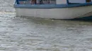 Para wisatawan menggunakan sebuah perahu menyusuri Sungai Tarcoles, Rio Grande, Kosta Rika, Jumat (13/3/2015). Buaya menjadi daya tarik objek wisata Sungai Tarcoles. (AFP Photo/Ezequiel Becerra)