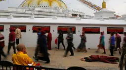 Seorang biksu bersujud selama Buddha Jayanti atau Buddha purnima di stupa Boudhanath, Kathmandu, Nepal (30/4). Festival ini menandai tiga peristiwa kehidupan Buddha Gautama. (AP/Niranjan Shrestha)