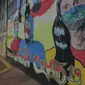 Pedagang melintas di depan mural anjuran kebiasan hidup baru dengan 3 M di Stasiun Cawang, Jakarta, Sabtu (26/12/2020). Pemerintah terus berupaya melakukan imbauan kepada warga untuk melaksanakan kebiasaan baru 3M guna memutus penyebaran virus corona (COVID-19). (merdeka.com/Imam Buhori)