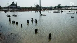 Banjir akibat pasang air laut di Desa Pantai Bahagia mengakibatkan pemakaman dan sekolah terendam serta akses jalan terputus, Jawa Barat, Jumat (9/6).(Liputan6.com/Gempur M Surya)